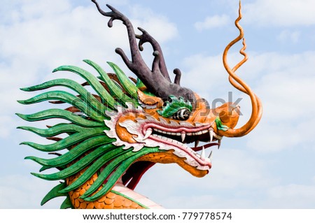 stone dragon statue in Thailand  with face close-up on blue sky background.   Religion, culture and art of Asia.
