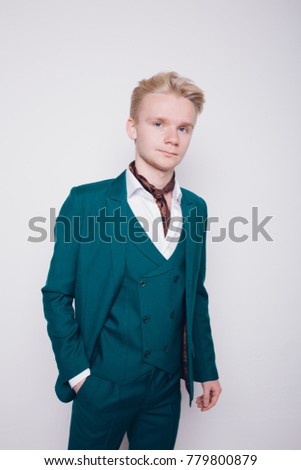 young man with white hair and a light complexion. business style: strict office blazer and colored pants. emotional portrait. clear skin and healthy hair. the desktop Wallpaper and clothing catalog