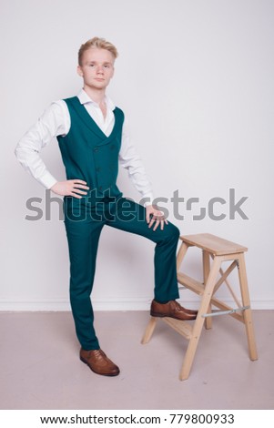 young man with white hair and a light complexion. business style: strict office blazer and colored pants. emotional portrait. clear skin and healthy hair. the desktop Wallpaper and clothing catalog