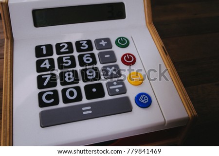 Plastic and wooden toy calculator on wooden desk texture. Concept for fun learning, mathematical thinking, business, accounting, finance.