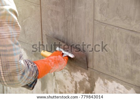 Cement Construction Business : The plasterer used plastering tools to smooth the surface.
