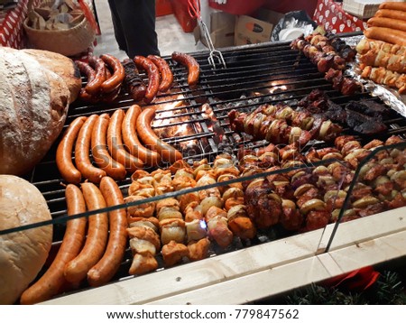 Assortment of grilled sausages on big hanging grill at Christmas market in Poznan, Poland - December 2017  Royalty-Free Stock Photo #779847562