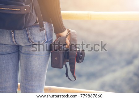 Travel camera woman in black look and take picture landscape of Mekong River from the top mountain with Soft light blurred view at bottom, Thailand,Vintage flim grain style.Soft focus for background.