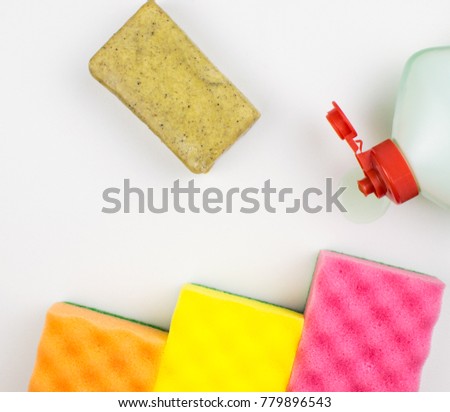 Multicolored foam rubber sponges, soap on a light background.
