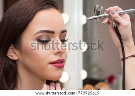 Makeup artist using airbrusher. Royalty-Free Stock Photo #779925619