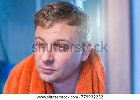 Man looks tired in the mirror after waking up