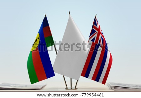 Flags of New Caledonia and Hawaii with a white flag in the middle