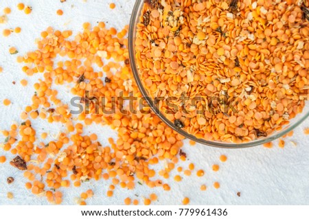 A flat view of the part of a plate filled with yellow mature lentil cracked seeds