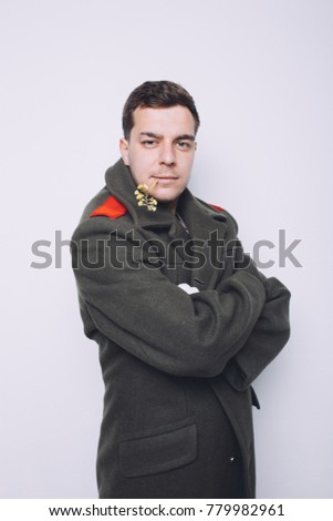 cheerful and positive guy posing in Studio on light background. dressed in military uniforms and white gloves. short hair and clean skin. emotional portrait. fooling around and Hamming to set the mood