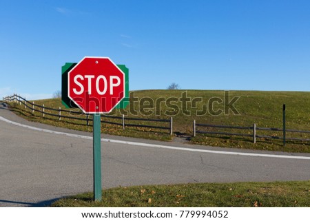 Stop sign in a bright daylight blue sky.