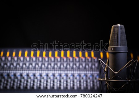 Recording Studio Scene with close up on mic and soft focus on mixer. Negative space available for copy, logo etc. Royalty-Free Stock Photo #780024247