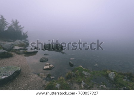 western carpathian mountain tops in  autumn covered in mist or clouds. panoramic view from a distance. mountain lake panorama - vintage film look