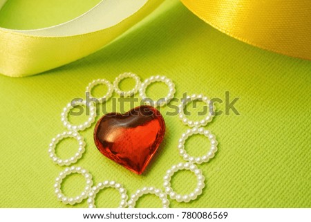 glass red heart around which the beaded circles, green background and ribbon shading