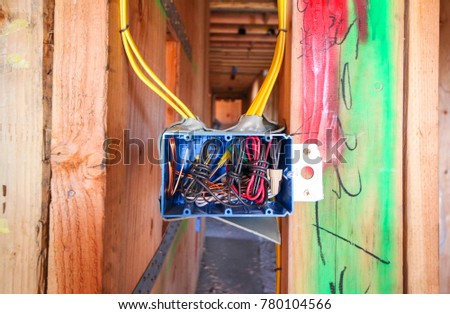 Electrical wiring in blue plastic electrical box installed on wood frame wall