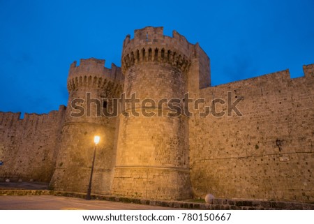 Two towers at the entrance in the port of the medieval town in Rhodes at sunset