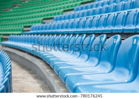 Empty rows with blue and green seats on a stadium 