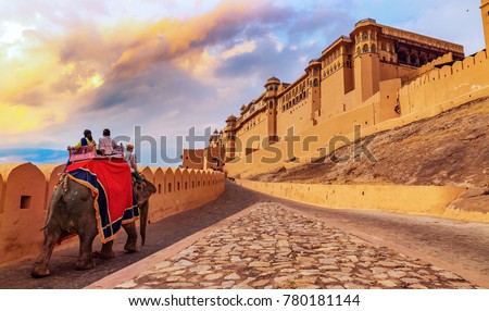 Tourists enjoy an elephant ride at Amer Fort Jaipur Rajasthan at sunset. Royalty-Free Stock Photo #780181144