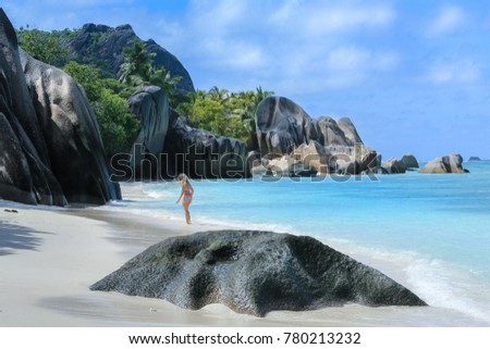A girl walking along the white sand of the ocean coast among the rocks.