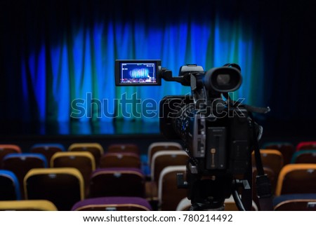 The LCD display on the camcorder. Shooting theatrical performances. The TV camera. Colorful chairs in the auditorium.