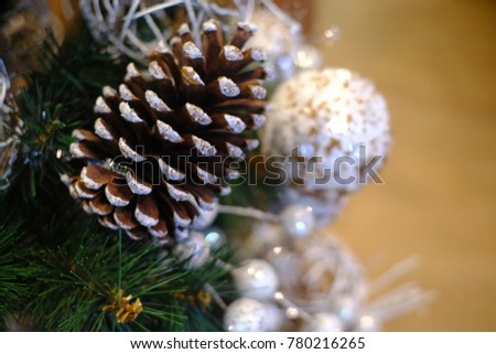 Pine cones on Christmas tree background and white Christmas ornaments with copy space for your text design. Vintage style. Concept be used for Christmas Day. Blurred picture.