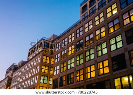 colorful picture of office building in the night with square formed facade