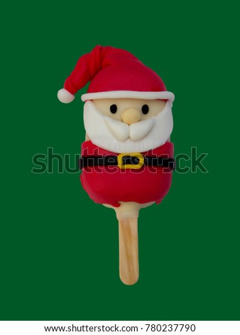 Christmas candies and ice cream decorated as santa claus on green background. New year and Christmas composition