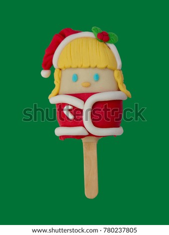 Christmas candies and ice cream decorated as santa girl on green background. New year and Christmas composition
