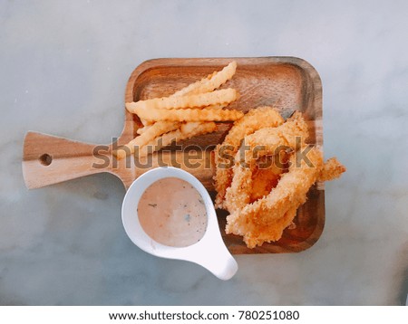 Flat lay of french fries, shrimp fries and cream sauce on wood plate place on white table. Concept be used for publish menu of restaurant business and appetizer of coffee shop. Blur picture.