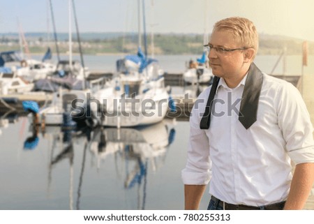 Businessman enjoying his after work at the pier for sailboat