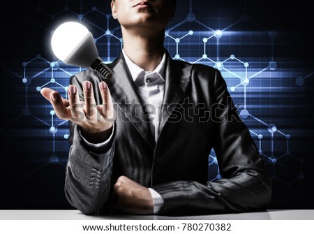 Businessman in suit presenting glowing lightbulb in hand as symbol of new idea, network connections on background. 3D rendering.