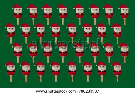 pattern of Christmas candies and ice cream decorated as santa claus on green background. New year and Christmas composition