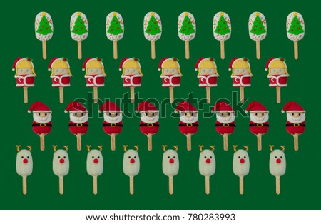 group of Christmas candies and ice cream decorated as santa claus, Christmas tree, girl and reindeer on green background. New year and Christmas composition