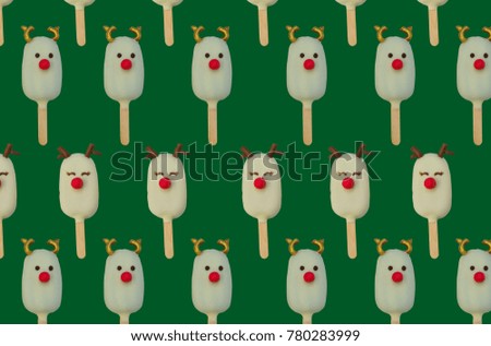 pattern of Christmas candies and ice cream decorated as reindeers on green background. New year and Christmas composition