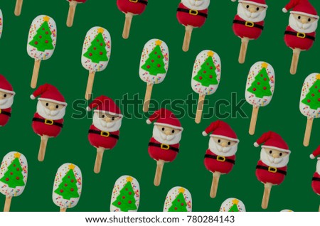 pattern of Christmas candies and ice cream decorated as santa claus and Christmas tree on green background. New year and Christmas composition