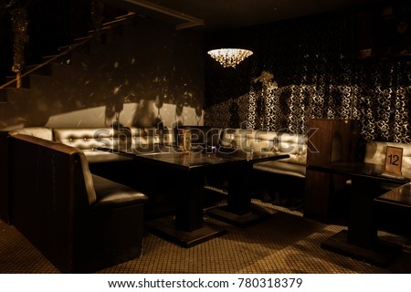 Intimate interior of luxury nightclub, restaurant. Concept of expensive relaxation and relaxation in nightly striptease bar.  black Glossy leather restaurant sofas. On sofas Intimate interior of rest