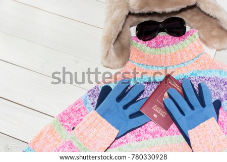 A tablet personal computer with a bright color sweater and warm hat. It is time to leave. Russian tourist.