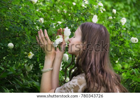 woman smelling a white rose