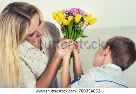  Son gives his beloved mother a beautiful bouquet of tulips.The concept of the celebration,women's day.