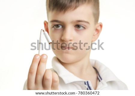 Studio shot of young boy breaking a cigarette, no smoking concept