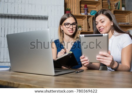 Business meeting of women on-line stores owners discuss new ideas for business expansion using laptop computer and touch pad. Two woman talking about joint work, watching webinar on digital tablet