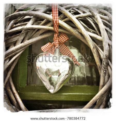 Shining silver heart hanging from red and white ribbon in middle of dried willow wreath for love on valentine's day 