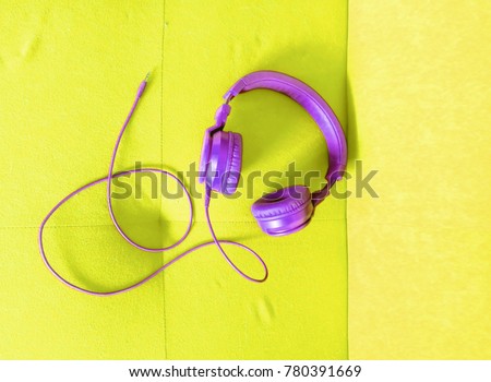 cool purple headphones on a yellow high visibility background