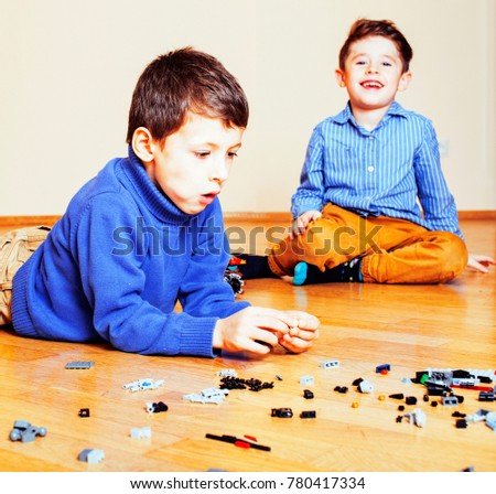 funny cute children playing toys at home, boys and girl smiling,
