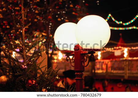 Round retro street lights surrounded by blurred festive illuminations lights.