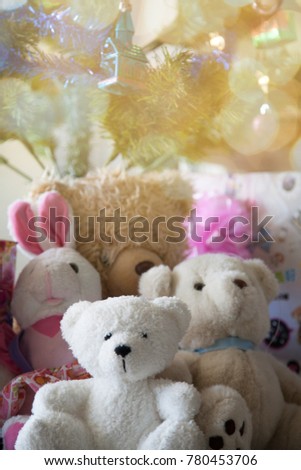Christmas tree branches with warm light and shining red and golden balls with  gift box and teddy bear on the floor