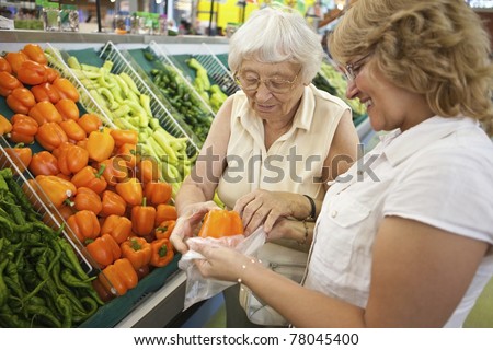 Volunteer helping senior with her shopping Royalty-Free Stock Photo #78045400