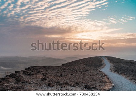 Landscape of colorful morning sunrise in aged judean desert Israel. Magic color dawn in holy land with beautiful nature clouds, mountains and rocks. Travel tourism and nobody on photo