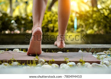 barefoot girl walking on the stone floor in outdoor with sunlight Royalty-Free Stock Photo #780494410