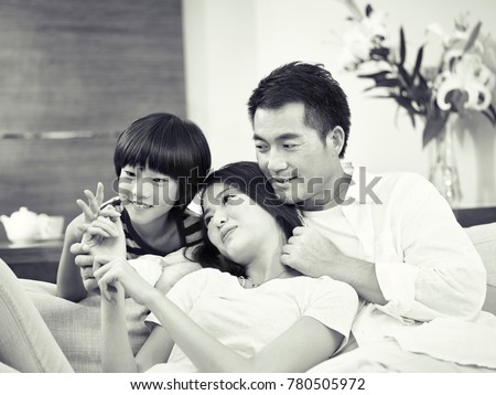 asian parents with one child enjoying time together at home, black and white