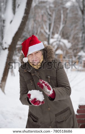 Middle aged woman having fun with the snowball